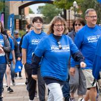 Participants walking by at the start of the event with blue shirts